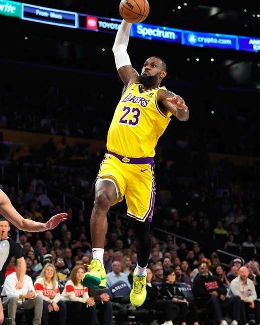 LeBron Jame, jugador de baloncesto en el aire, encestando el balón, durante un juego.