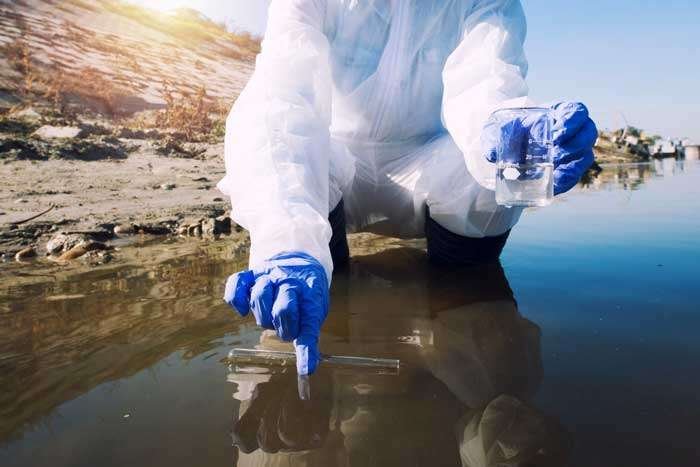 Una científica toma agua de un río contaminado. La gastroenteritis es causada por tomar agua contaminada.
