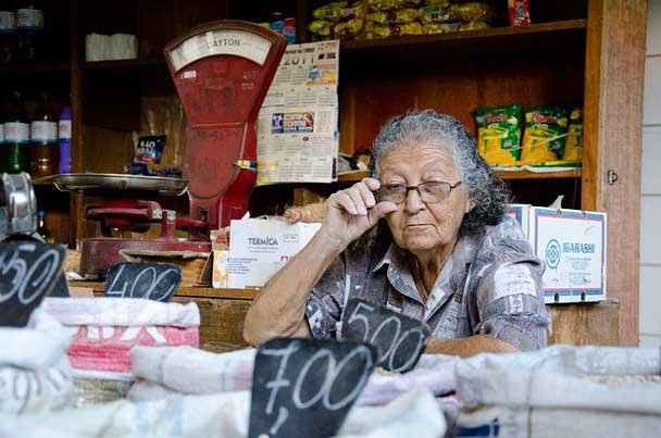 Imagen de una mujer, dueña de una tienda, quien se encuentra en su negocio.