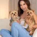 Carmen Villalobos cargando a sus queridas mascotas, dos perros raza yorkshire terriers.