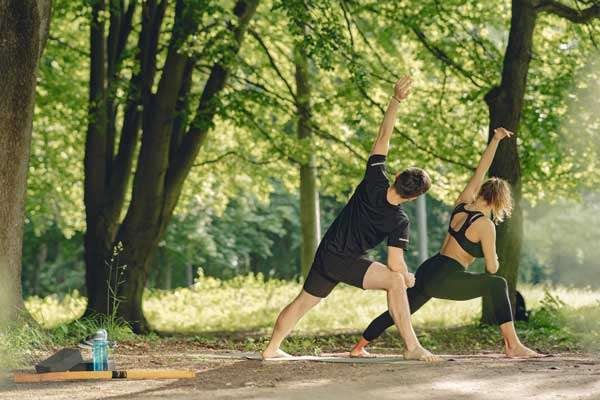 Un hombre y una mujeres realizando ejercicios en un parque