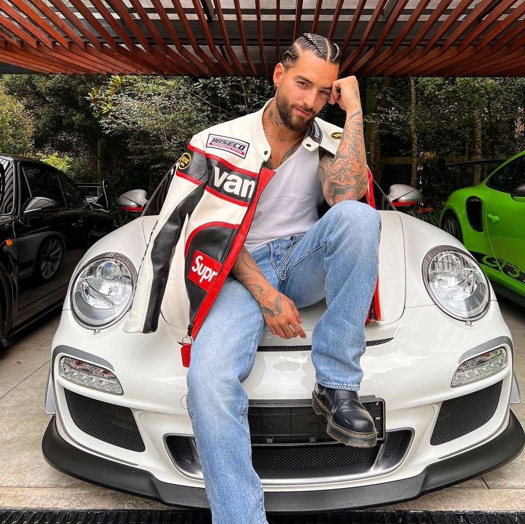 Maluma cantante colombiano sobre uno de sus carros, un porshe.