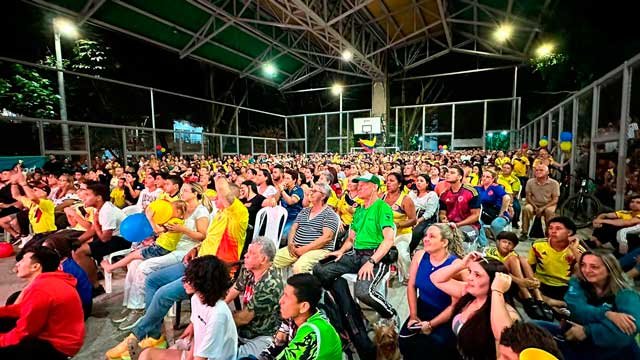 Un grupo de personas sentadas en Medellín viendo el partido de la Selección Colombia de fútbol en la Copa América.