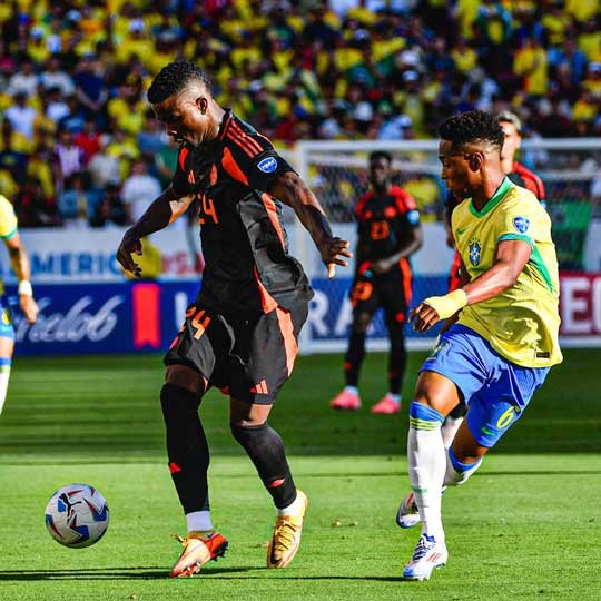 Un jugador de la Selección Colombia de Fútbol disputa el balón con otro de Brasil, durante un partido de la Copa América.